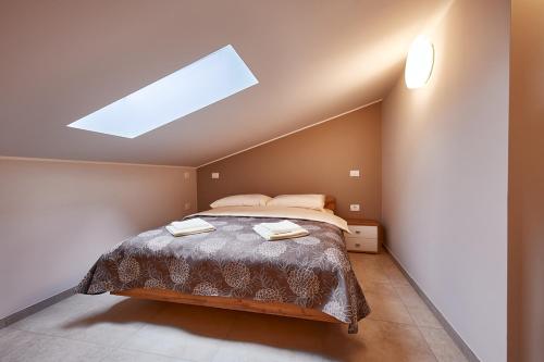 a bedroom with a bed and a skylight at Posestvo Rouna - winery and apartments in Vipava
