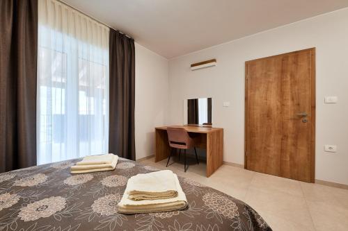 1 dormitorio con cama, escritorio y ventana en Posestvo Rouna - winery and apartments en Vipava