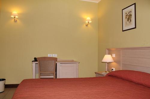 a bedroom with a bed and a desk and a chair at Il Parco Sul Mare Resort & SPA in Tortoreto Lido