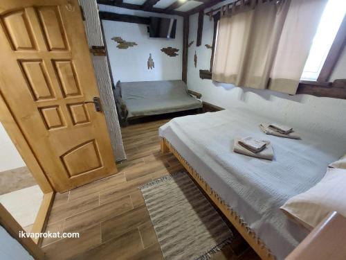 a bedroom with a bed and a door and a window at Котеджі Цімбори in Yablunytsya