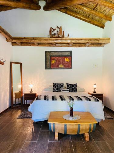 a bedroom with a bed and a wooden table at Casa de Coria in Chacras de Coria