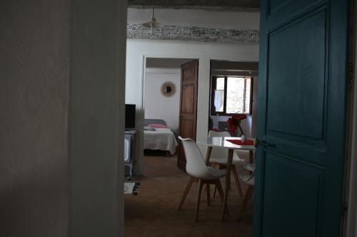 a room with a table and chairs and a bedroom at La Maison de Michele in Le Fugeret