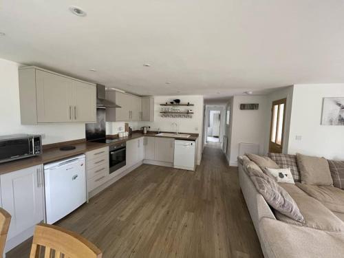 a kitchen and living room with a couch and a table at The Lambing Lodge in Swanton Morley