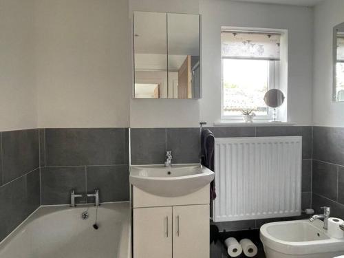 a bathroom with a sink and a tub and a toilet at The Lambing Lodge in Swanton Morley