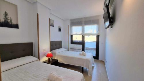 Posada de LlanesにあるApartamento La Terraza del Paraisoのベッドが2つと窓があるホテルの部屋