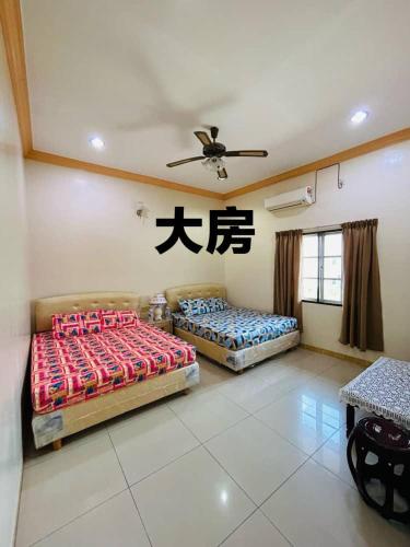 a room with two beds and a ceiling fan at Hotel Langkap 冷甲酒店 in Kampung Degong