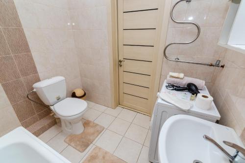 y baño con aseo blanco y lavamanos. en В спокойном районе в центре города - 2 комнатная en Almaty