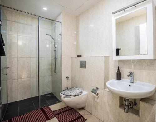a bathroom with a toilet and a sink and a shower at 1 Bedroom Luxury Furnished Apartment in East Legon in Accra