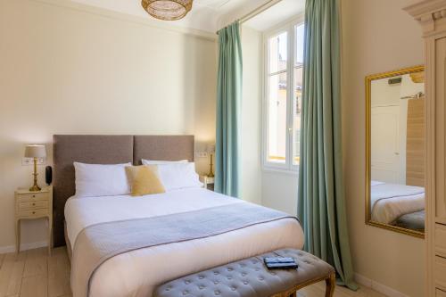 Hotel les Armoiries في فالبون: غرفة نوم بسرير كبير ومرآة