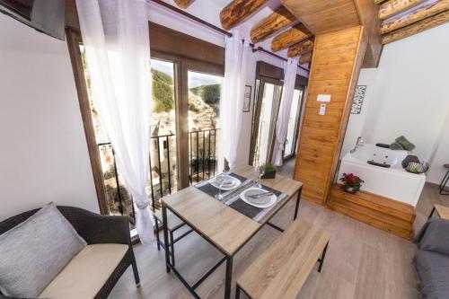 a living room with a table and chairs and a balcony at Casa Villar in Alcalá del Júcar