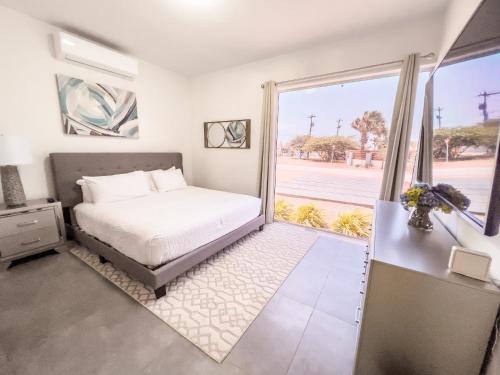 a bedroom with a bed and a large window at GRAND Modern villa 6-Bedroom Brand New Heated Jacuzzi in Palm-Eagle Beach