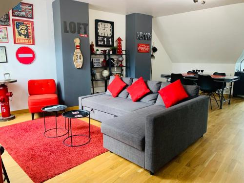 - un salon avec un canapé gris et des oreillers rouges dans l'établissement Amiens LOFT, à Amiens