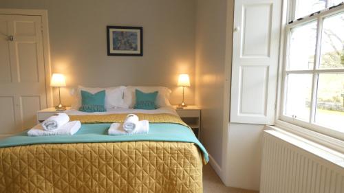 a bedroom with a bed with towels on it at Kirkland House B&B in Tarbert