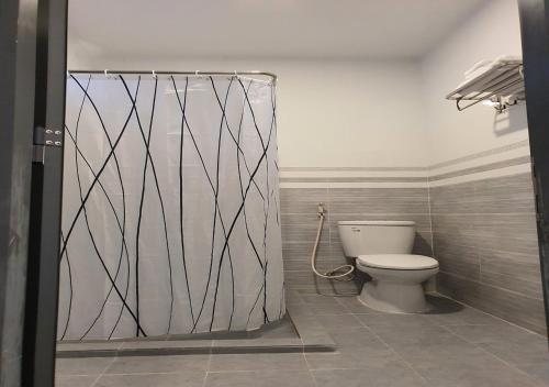 łazienka z toaletą i zasłoną prysznicową w obiekcie Bungalow VinaHouse w Duong Dong