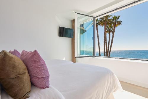 a bedroom with a bed with a view of the ocean at Suite Deluxe Face Mer Apart Malaga in Málaga