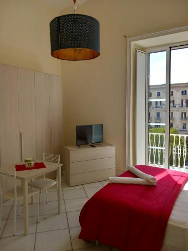 a bedroom with a bed and a table and a window at La Casa di Elvira in Naples