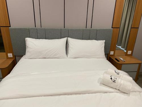 a white bed with white pillows and a towel on it at MESA Thamrin City Apartments at Nagoya with Netflix & Pick Up Service in Nagoya