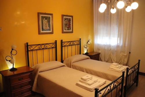 two beds in a room with yellow walls at Casa nel Delta del Po in Scardovari