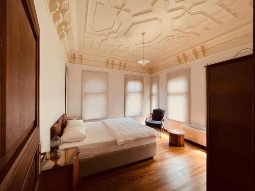 ein Schlafzimmer mit einem Bett und einem Stuhl in einem Zimmer in der Unterkunft Historic Greek Pavillion Golden Horn Istanbul in Istanbul