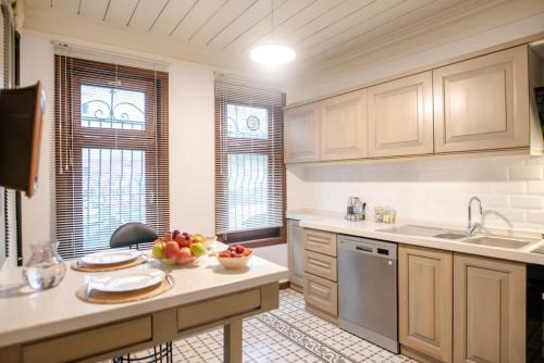 a kitchen with white cabinets and a bowl of fruit on a counter at Historic Greek Pavillion Golden Horn Istanbul in Istanbul