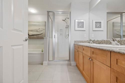 a white bathroom with a shower and a sink at Totally Beach'n at 1605 Aqua in Panama City Beach