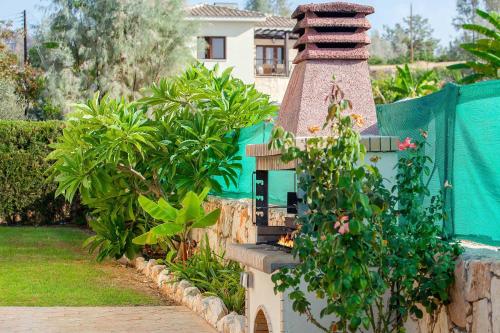 a garden with a bird house in front of a house at Villa Styliani in Argaka