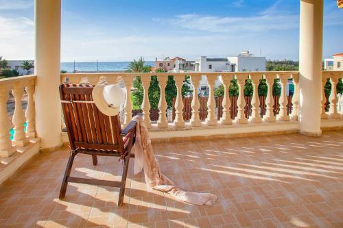 a rocking chair on a balcony with a fence at Villa Styliani in Argaka