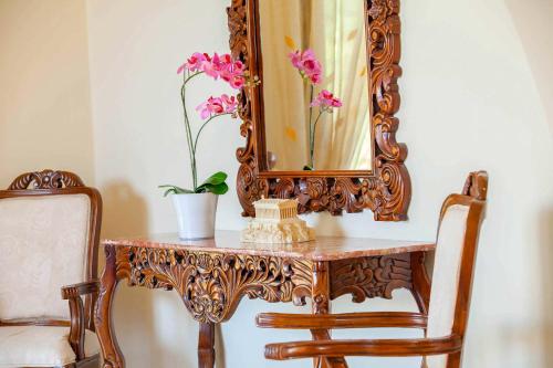 a table with a mirror and a vase with flowers on it at Villa Styliani in Argaka