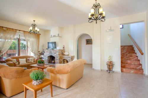 a living room with couches and a fireplace at Villa Styliani in Argaka