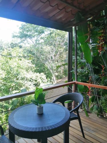 a blue table and chairs on a porch with a window at Finca Los Caballos Montezuma in Montezuma