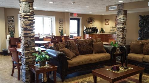 a waiting room with couches and tables and a kitchen at Stonebrook Lodge in Cherokee