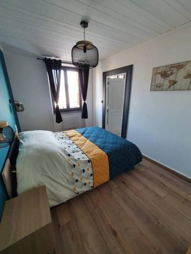 une chambre avec un lit et un parquet dans l'établissement Logis des Bouchons, à Morteau