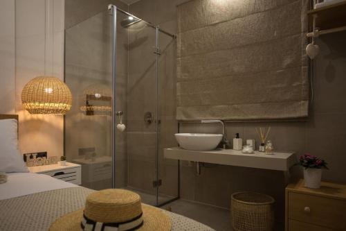 a bathroom with a shower and a sink and a bed at Cozzzy. Exclusive Apartment. in Thessaloniki