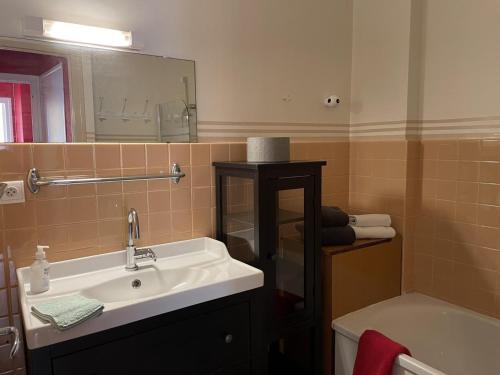 W łazience znajduje się umywalka, lustro i wanna. w obiekcie Appartement Vichy, 2 pièces, 2 personnes - FR-1-489-302 w mieście Vichy