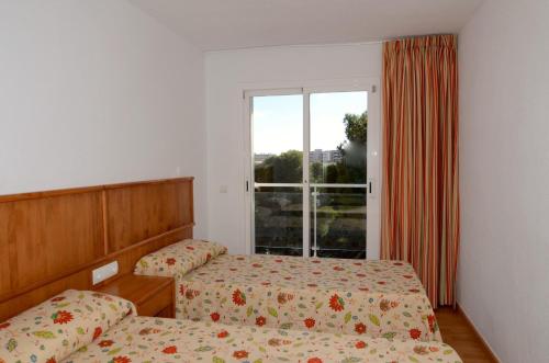 - une chambre avec 2 lits et une fenêtre dans l'établissement Apartamento Duplex BONSOL 14, à L'Estartit