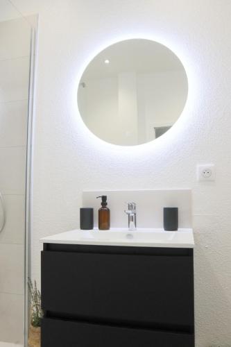 une salle de bain avec un lavabo et un miroir dans l'établissement L'échappée belle, proche gare centrale, à Mulhouse