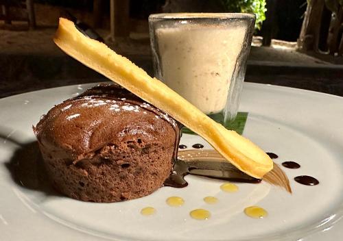 a white plate with a chocolate dessert and a glass of milk at Château de feuilles & SPA - Praslin island in Baie Sainte Anne