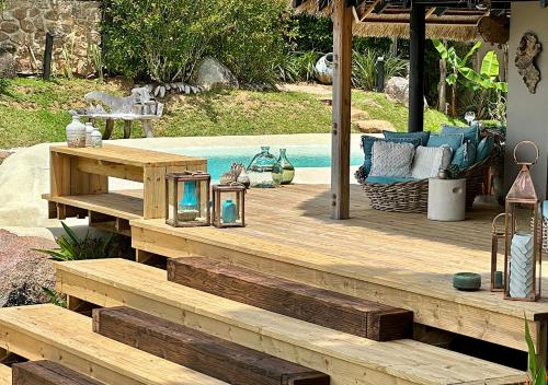 a wooden deck next to a swimming pool at Château de feuilles & SPA - Praslin island in Baie Sainte Anne