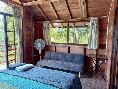1 dormitorio con sofá azul y ventana en L'Oasis Don Juan, en Don Juan