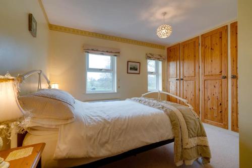 a bedroom with a large bed and a table at Barley Cottage in Whittington