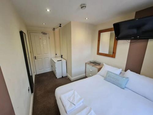 um quarto com uma grande cama branca e um espelho em Lovely bedroom em Londres