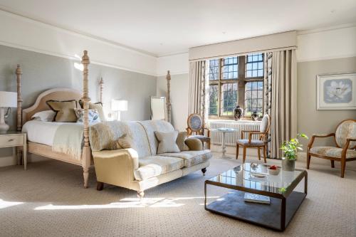 a bedroom with a bed and a couch and a table at The Greenway Hotel & Spa in Cheltenham