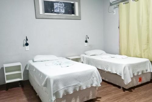 two beds in a hospital room with white sheets at Mindú Park Hotel in Manaus
