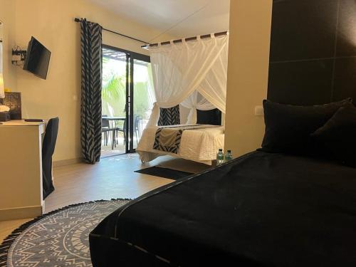 a bedroom with a bed and a door to a patio at Villa Le Petit Paradis Saly Boutique Hotel in Ngaparou