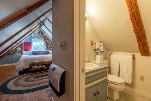 a bathroom with a bed and a sink in a attic at Beautiful Historic 4-Season Country Estate in Okemo Valley in Cavendish