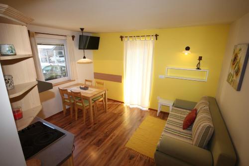 a living room with a couch and a table at Apartments Na Vasi in Bohinj