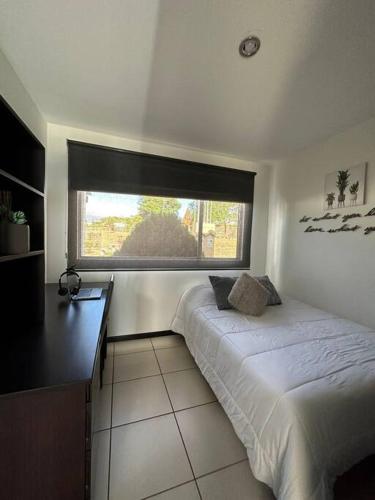 a small bedroom with a bed and a window at Casa a 4km del aeropuerto SJO in Santiago Este