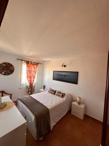 a bedroom with a bed and a television on the wall at La Casita in Costa de Antigua