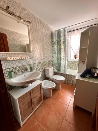 a bathroom with a sink and a toilet and a mirror at La Casita in Costa de Antigua