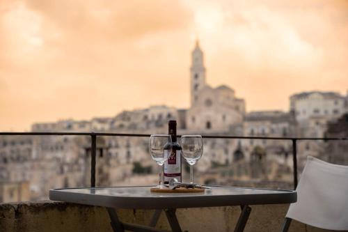 stół z 2 kieliszkami i butelką wina w obiekcie Residence Le Vie Del Mosto w mieście Matera